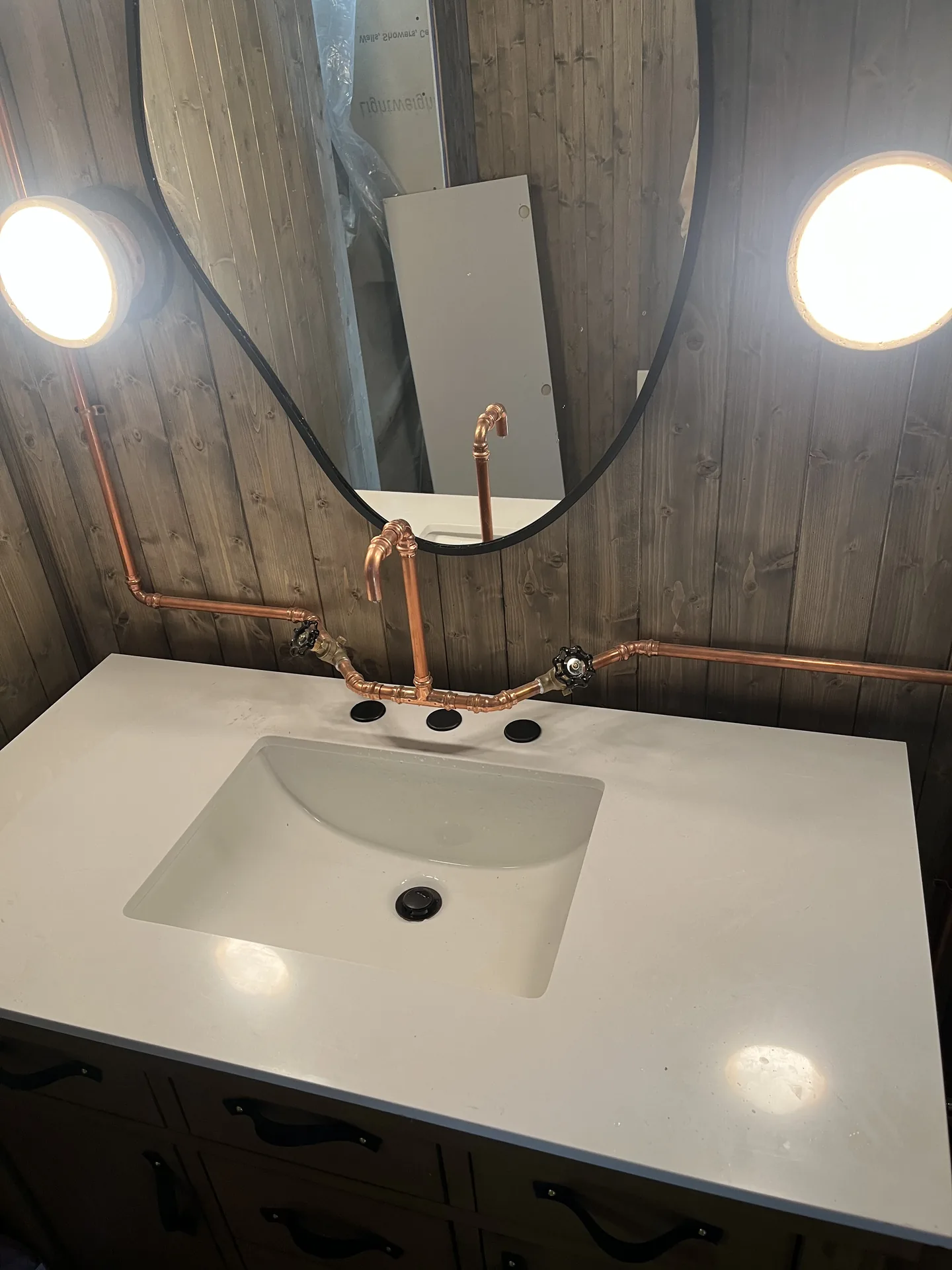 Finished bathroom vanity with sink and faucet installed in a rustic bathroom.
