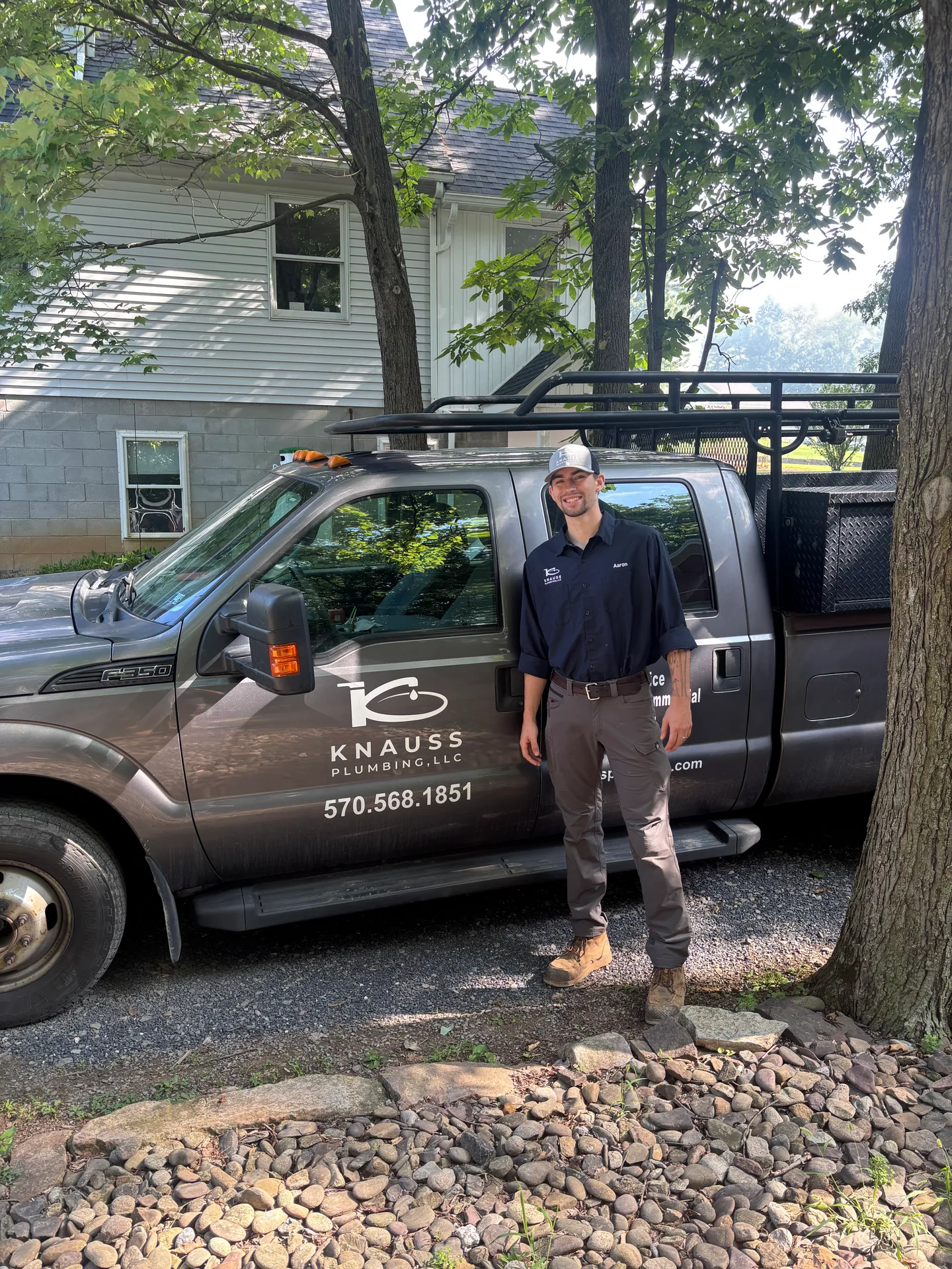 Knauss Plumbing owner standing beside the Knauss Plumbing service van.