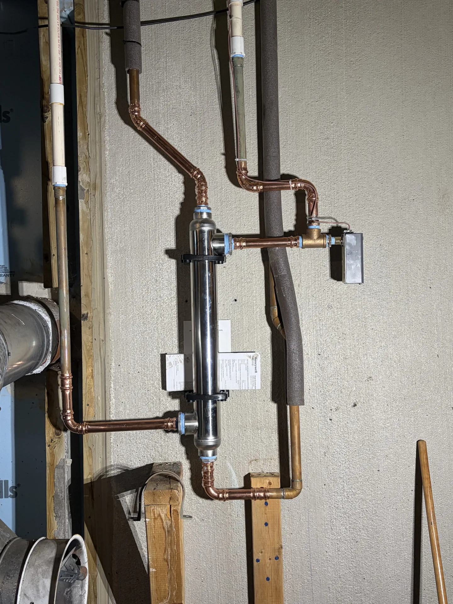 Clean copper plumbing lines and shutoff valves in a mechanical room.